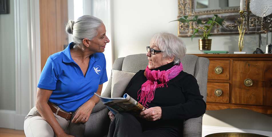 A Visiting Angels caregiver comforting an elderly woman with Alzheimer's, highlighting compassionate support in a peaceful home setting.