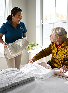 A Visiting Angels caregiver and an elderly man engaging in a thoughtful conversation, illustrating support and connection for individuals with Alzheimer's.