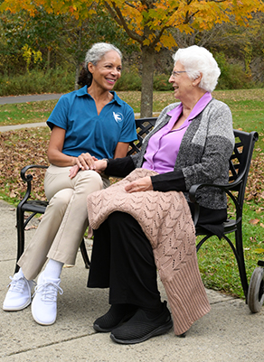 A Visiting Angels caregiver and an elderly man engaging in a thoughtful conversation, illustrating support and connection for individuals with Alzheimer's.