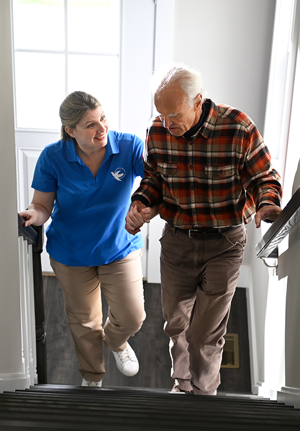 A Visiting Angels caregiver and an elderly man engaging in a thoughtful conversation, illustrating support and connection for individuals with Alzheimer's.