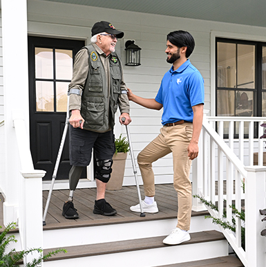 A Visiting Angels caregiver demonstrating proper techniques for using mobility aids with an elderly man, emphasizing fall prevention in a home setting.