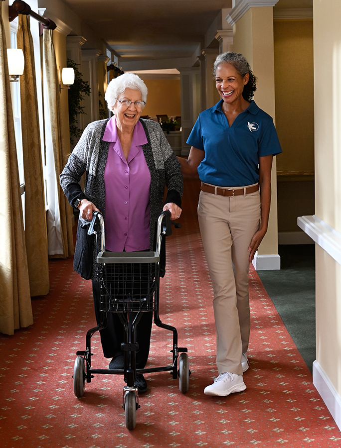 A Visiting Angels caregiver gently holding the hand of an elderly patient, illustrating compassion and support in palliative care.