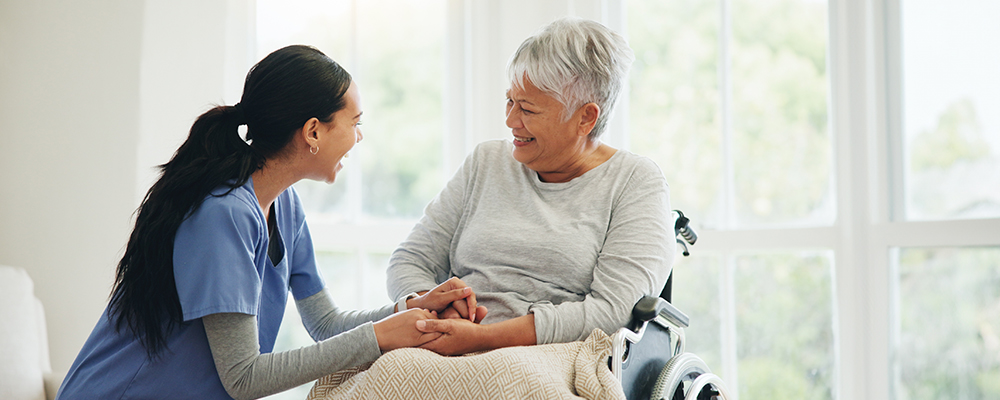 A Visiting Angels caregiver comforting an elderly woman with Alzheimer's, highlighting compassionate support in a peaceful home setting.