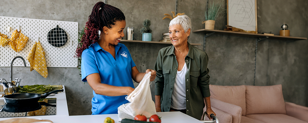 A Visiting Angels caregiver comforting an elderly woman with Alzheimer's, highlighting compassionate support in a peaceful home setting.