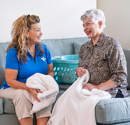 A Visiting Angels caregiver comforting an elderly woman with Alzheimer's, highlighting compassionate support in a peaceful home setting.