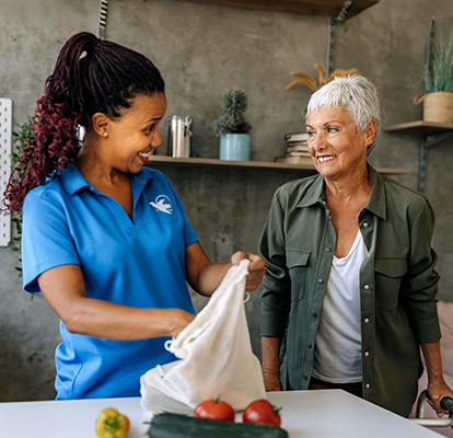 A Visiting Angels caregiver comforting an elderly woman with Alzheimer's, highlighting compassionate support in a peaceful home setting.