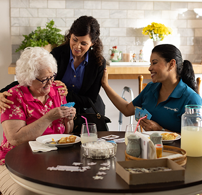 A Visiting Angels caregiver comforting an elderly woman with Alzheimer's, highlighting compassionate support in a peaceful home setting.