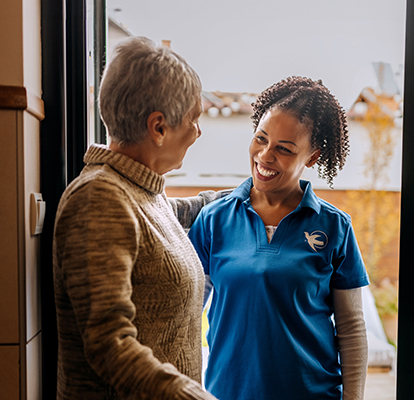 A Visiting Angels caregiver comforting an elderly woman with Alzheimer's, highlighting compassionate support in a peaceful home setting.