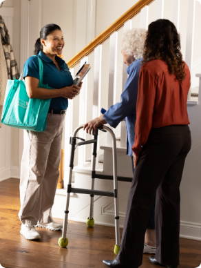 A Visiting Angels caregiver gently holding the hand of an elderly patient, illustrating compassion and support in palliative care.